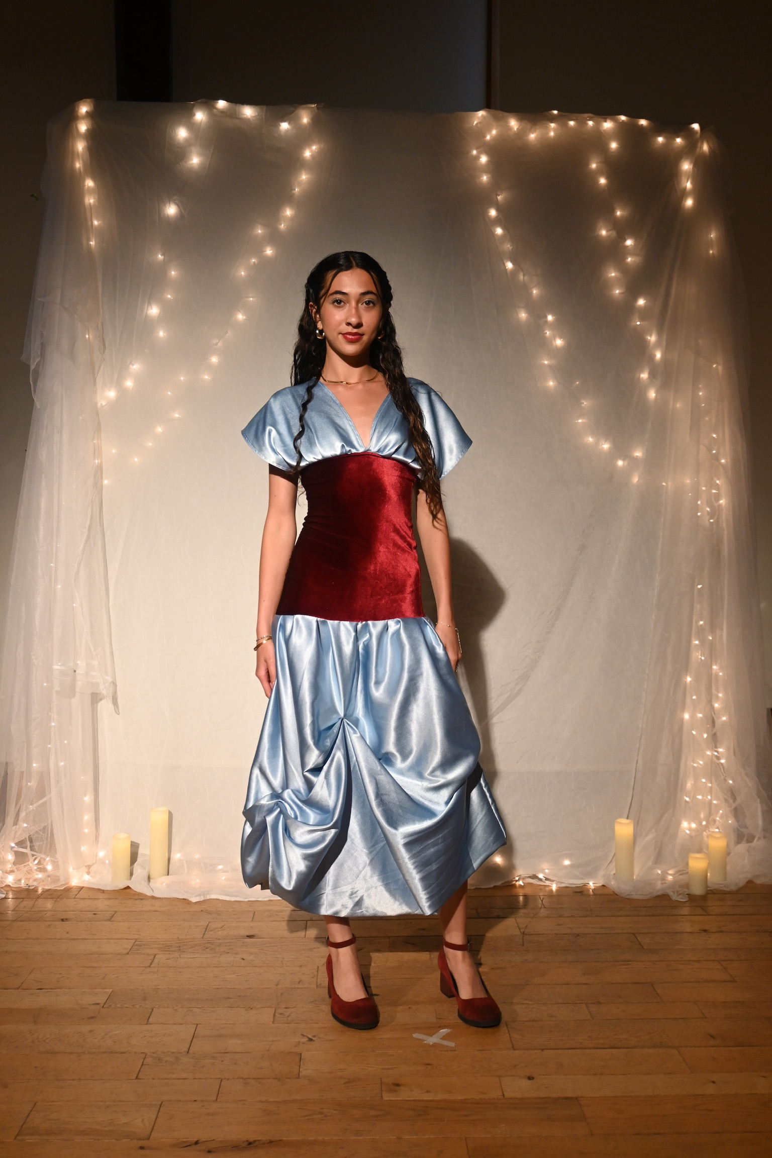 Model in a satin blue puff-sleeve gown with a red velvet bodice, front view, ENNA runway show