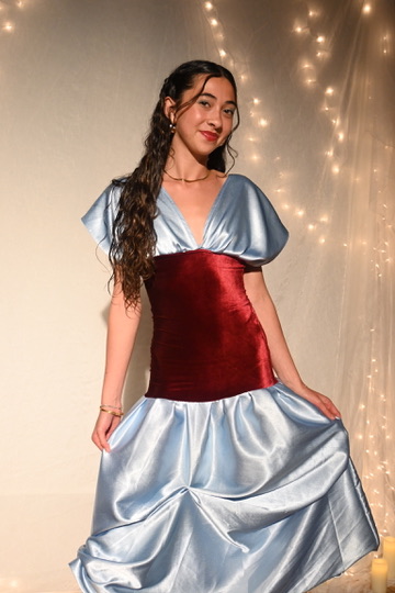 Model in a powder-blue satin gown with a burgundy velvet waist panel, ENNA runway show
