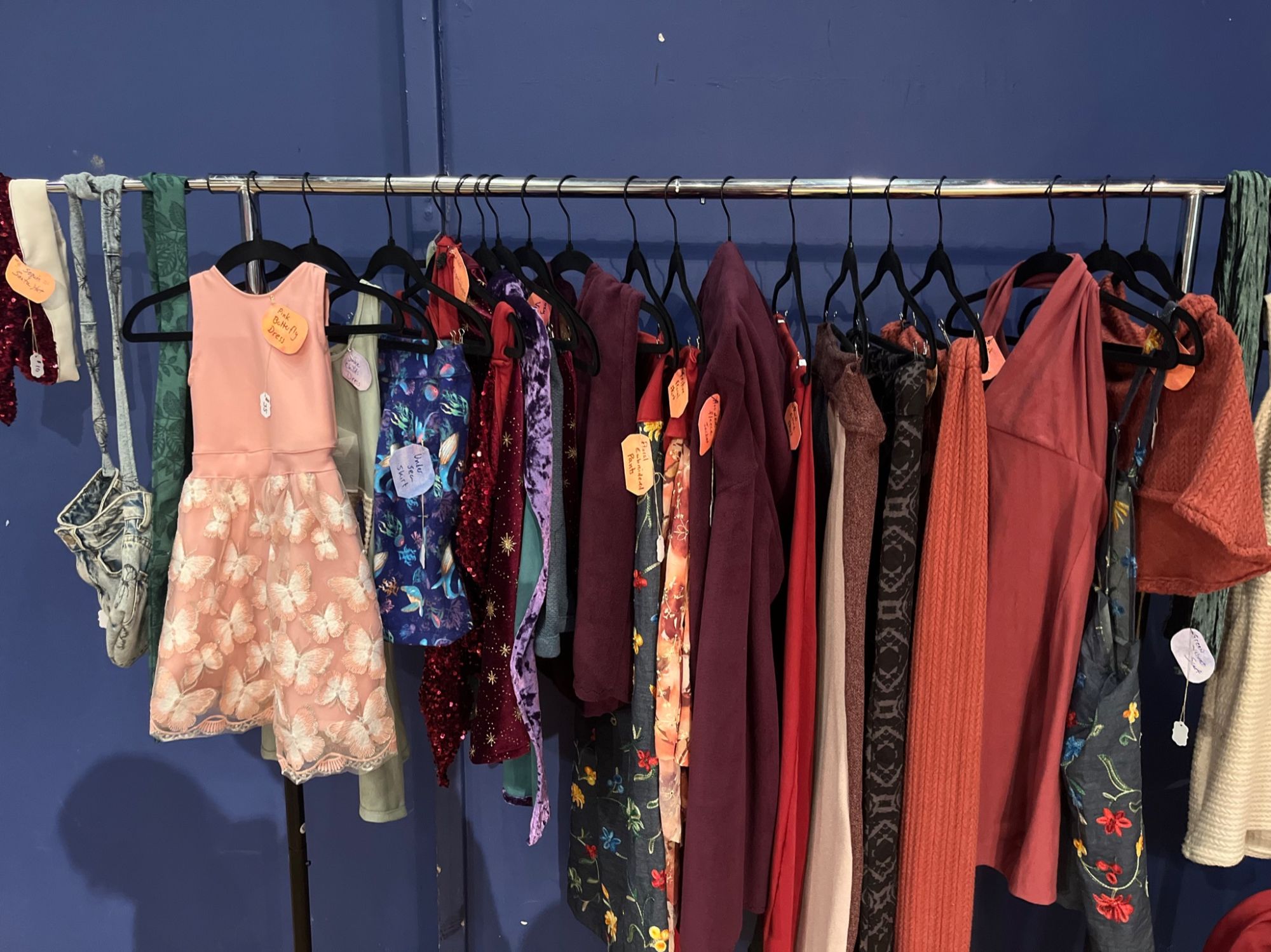 Clothing rack of handmade ENNA ready-to-wear pieces with price tags