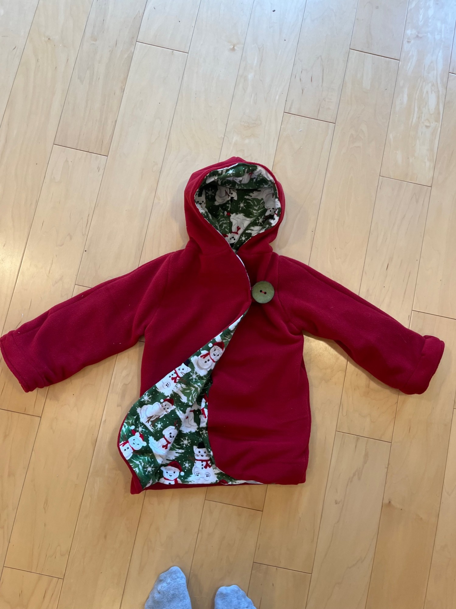Red hooded fleece robe for kids with a snowman print lining, laid flat