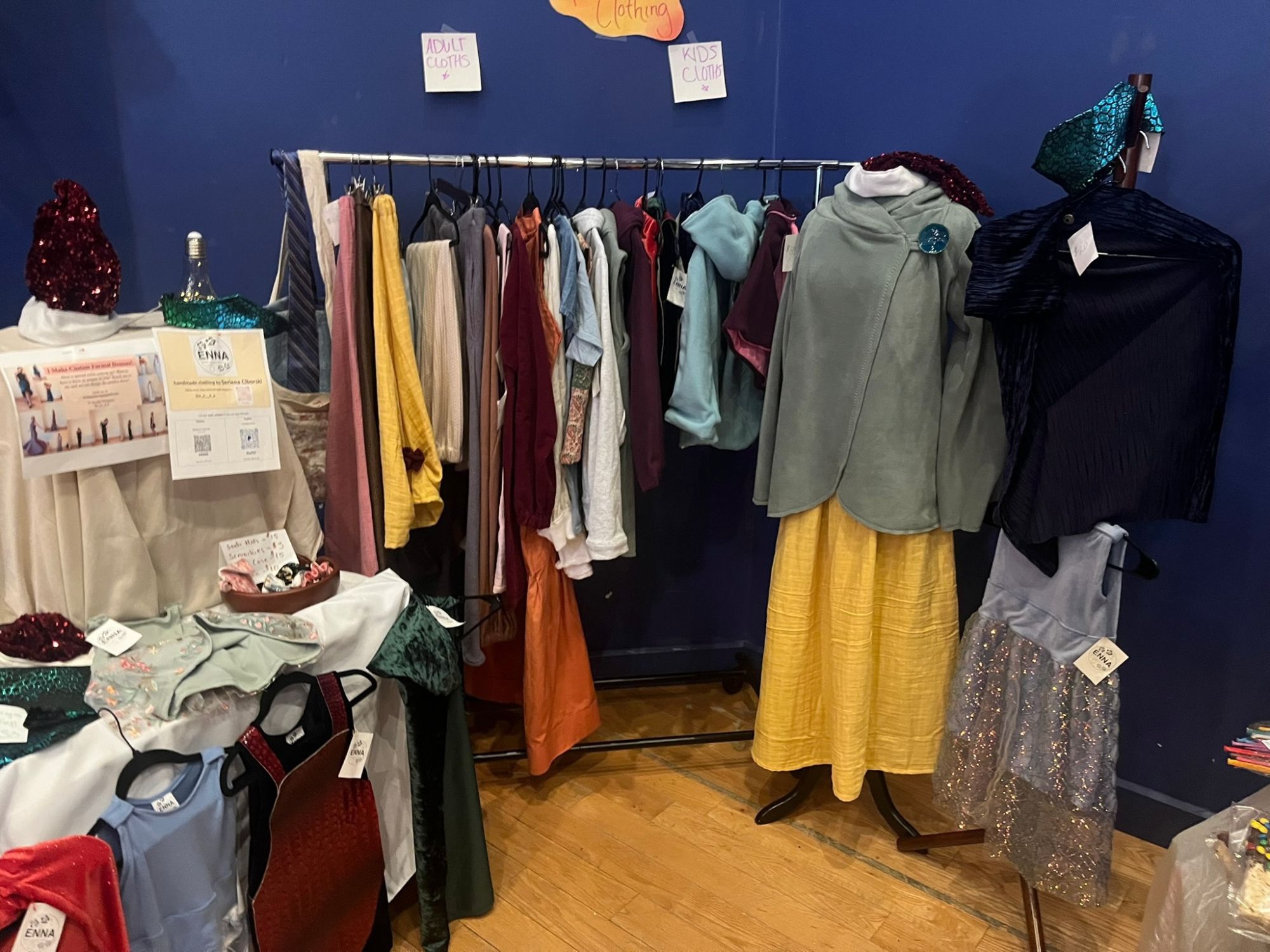 Full ENNA craft fair booth display with a clothing rack and mannequin