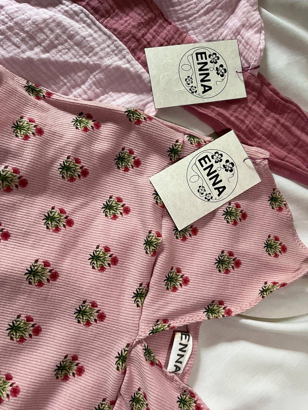 Close-up of two pink cotton gauze pieces with hand-sewn ENNA tags